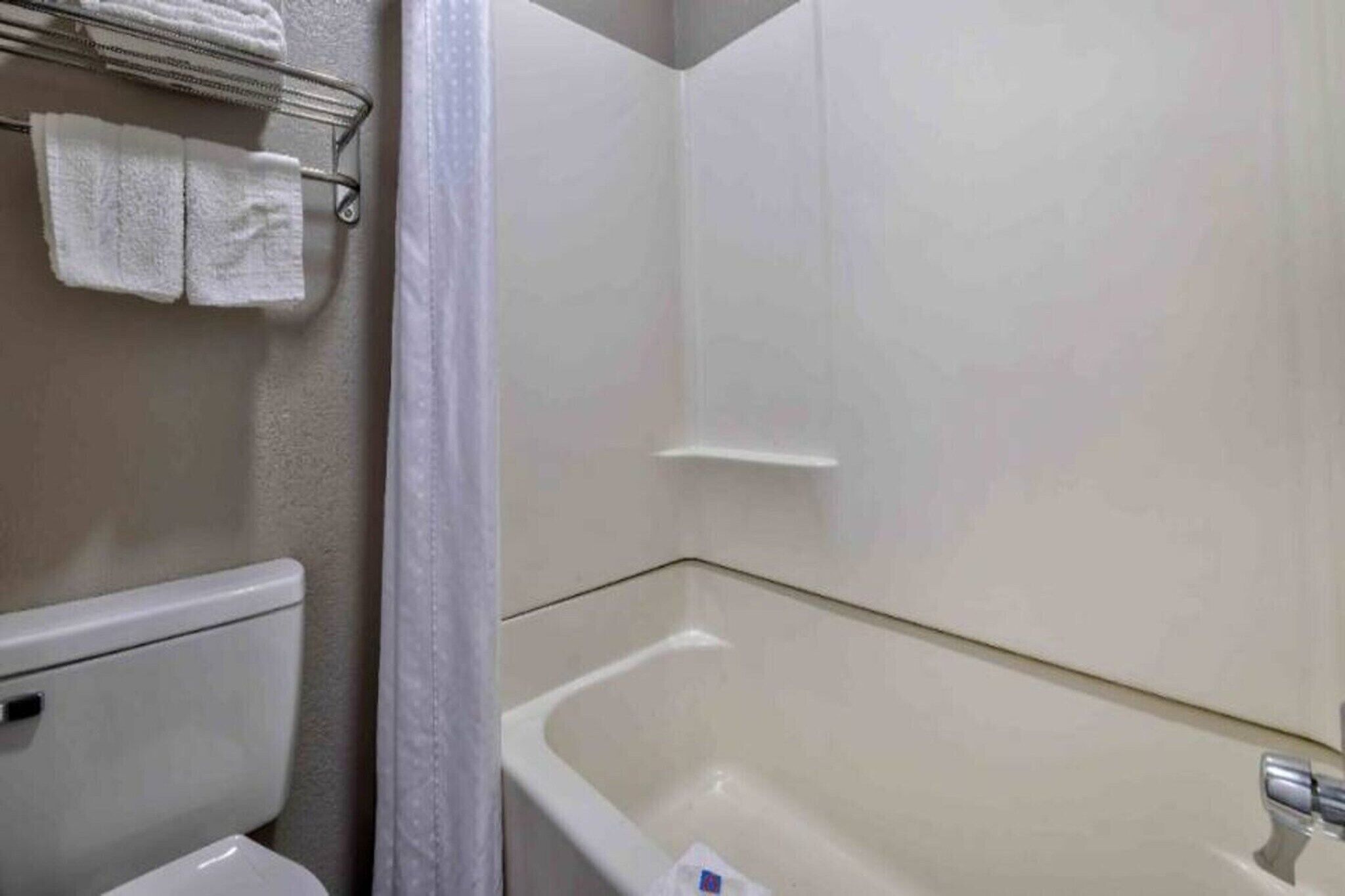 Une salle de bain équipée de toilettes, d’une baignoire et d’un porte-serviettes avec des serviettes.