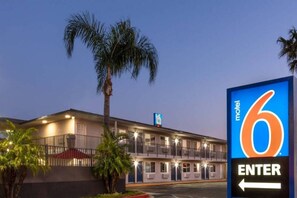 Motel amb un cartell que indica 'motel 6' i una fletxa amb la paraula 'ENTRA'.