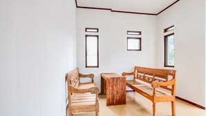A room with a wooden bench, a small table, and two windows. - Cozy Double Escape W/ Free Wifi and Parking (Purwokerto)