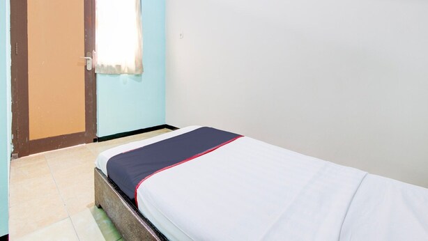 A single bed in a room with a door and a window. - Cozy Double Escape W/ Free Wifi and Parking (Purwokerto)