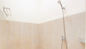 A small, tiled shower area with a handheld showerhead and a step stool. - Cozy Double Escape W/ Free Wifi and Parking (Purwokerto)