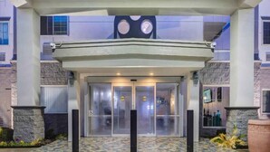 A hotel entrance with a patterned floor, double doors, and a large clock above the doors. - 2 Queen Beds | Mobil Access Tub Nsmk Micfridg (Balch Springs)