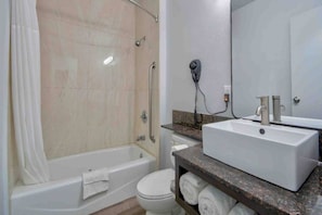A bathroom with a bathtub, toilet, and sink.