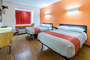 A hotel room with two beds, a desk, a chair, a window with red curtains, and a wall-mounted light fixture. - 2 Queen Beds|NS| Micfridge (Indianapolis IN)