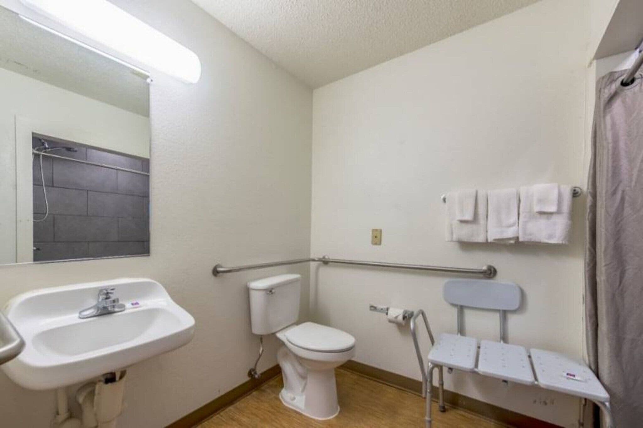 Une petite salle de bain propre, avec un lavabo blanc, des toilettes et un espace douche.