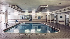 En indendørs swimmingpool med dybdemarkering på 97 centimeter, omgivet af flisegulv og med stiger.