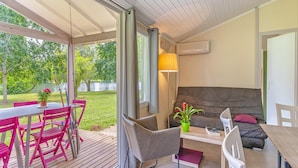 Una habitación moderna con techo de madera, un sofá, una mesa y sillas.