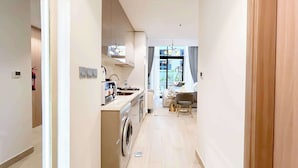 Un appartement moderne doté d’une cuisine, d’un coin repas et offrant une vue sur l’extérieur.