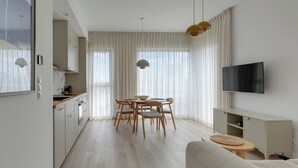 A modern kitchen with a dining area, a TV, and a sofa. - Sol Marina- Przystań by Grand Apartments (Pruszcz Gdanski)