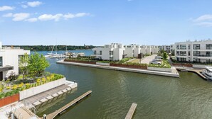 A waterfront property with modern architecture, a marina, and a view of the water. - Sol Marina- Przystań by Grand Apartments (Pruszcz Gdanski)