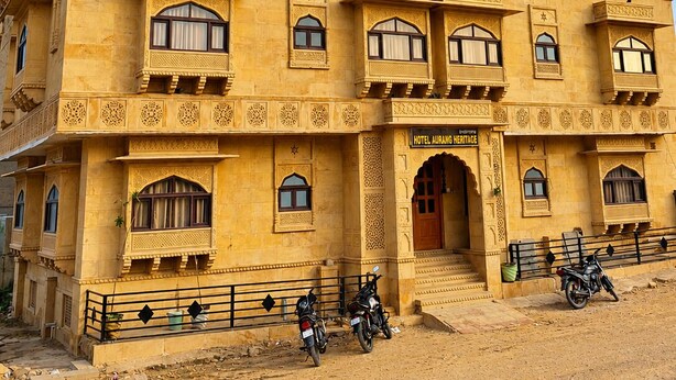 A multi-story building with a traditional architectural style, featuring balconies and ornate window designs. - Hotel Aurang Heritage (Jaisalmer)