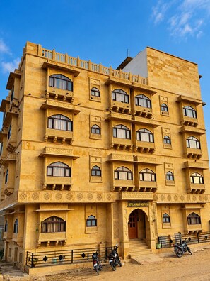 Un edificio de varios pisos con un estilo arquitectónico tradicional, que cuenta con balcones y diseños de ventanas ornamentados.