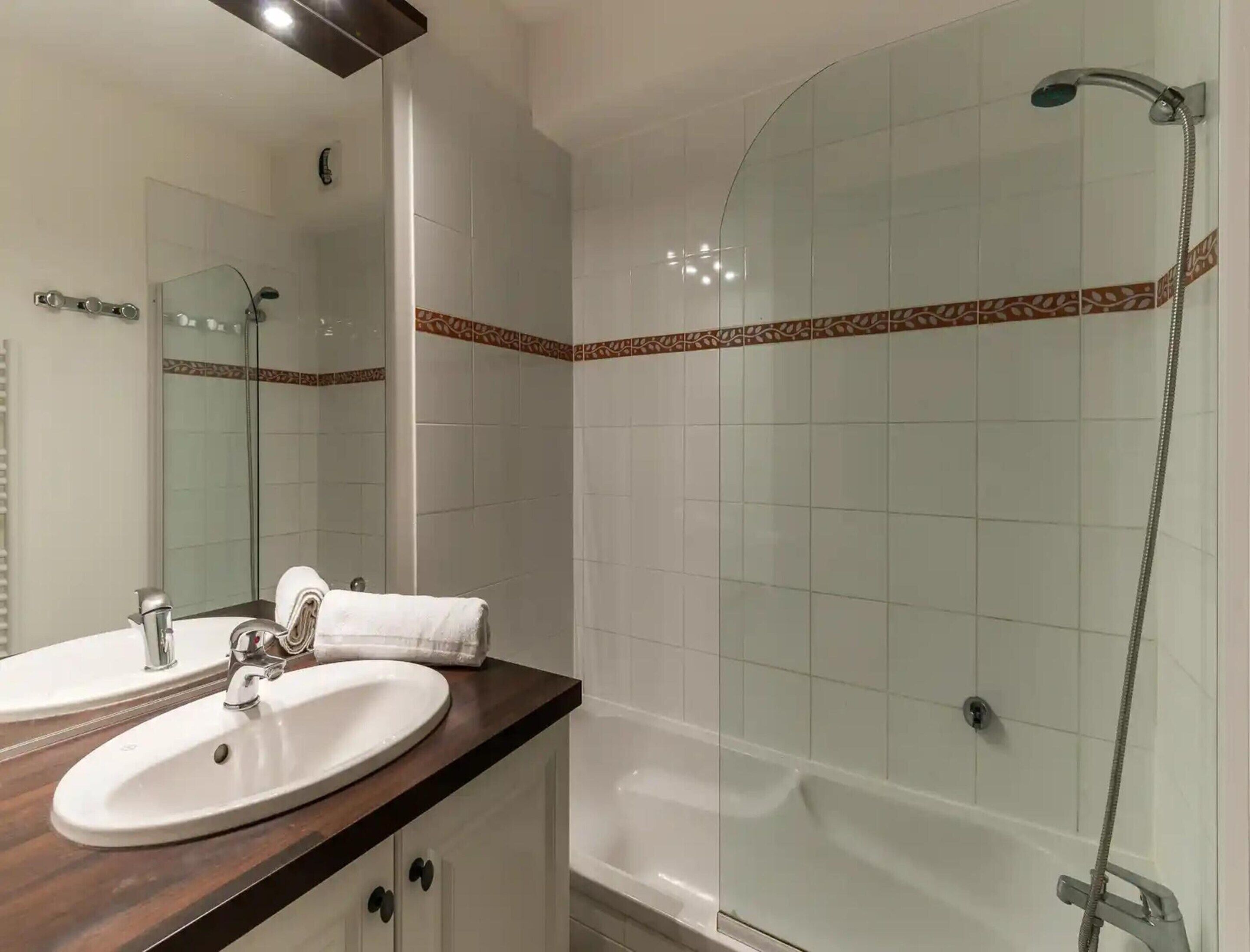 A bathroom with two sinks, a mirror, a shower, and a bathtub.