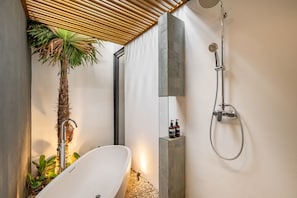 A modern bathroom with a freestanding bathtub, a shower with a handheld hose, and a potted palm plant. - Perfect 3-bedroom Villa with AC in enjoyable Ubud location (Gianyar)