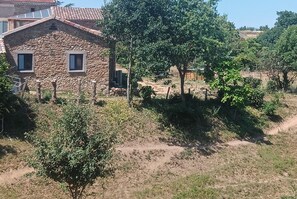A stone building with two windows, surrounded by greenery and a dirt path. - L'élixir, a cozy bed-and-breakfast in Ardèche, surrounded by nature, where you can bring your dog (Sécheras)