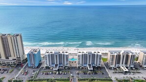 Ein Strandhotel mit mehreren Hochhäusern, einem Parkplatz und Blick auf den Ozean.