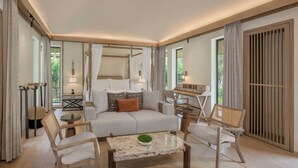 A spacious living room with a sofa, chairs, a coffee table, and a window with curtains. - JW Marriott Ranthambore Resort & Spa (Sawai Madhopur)