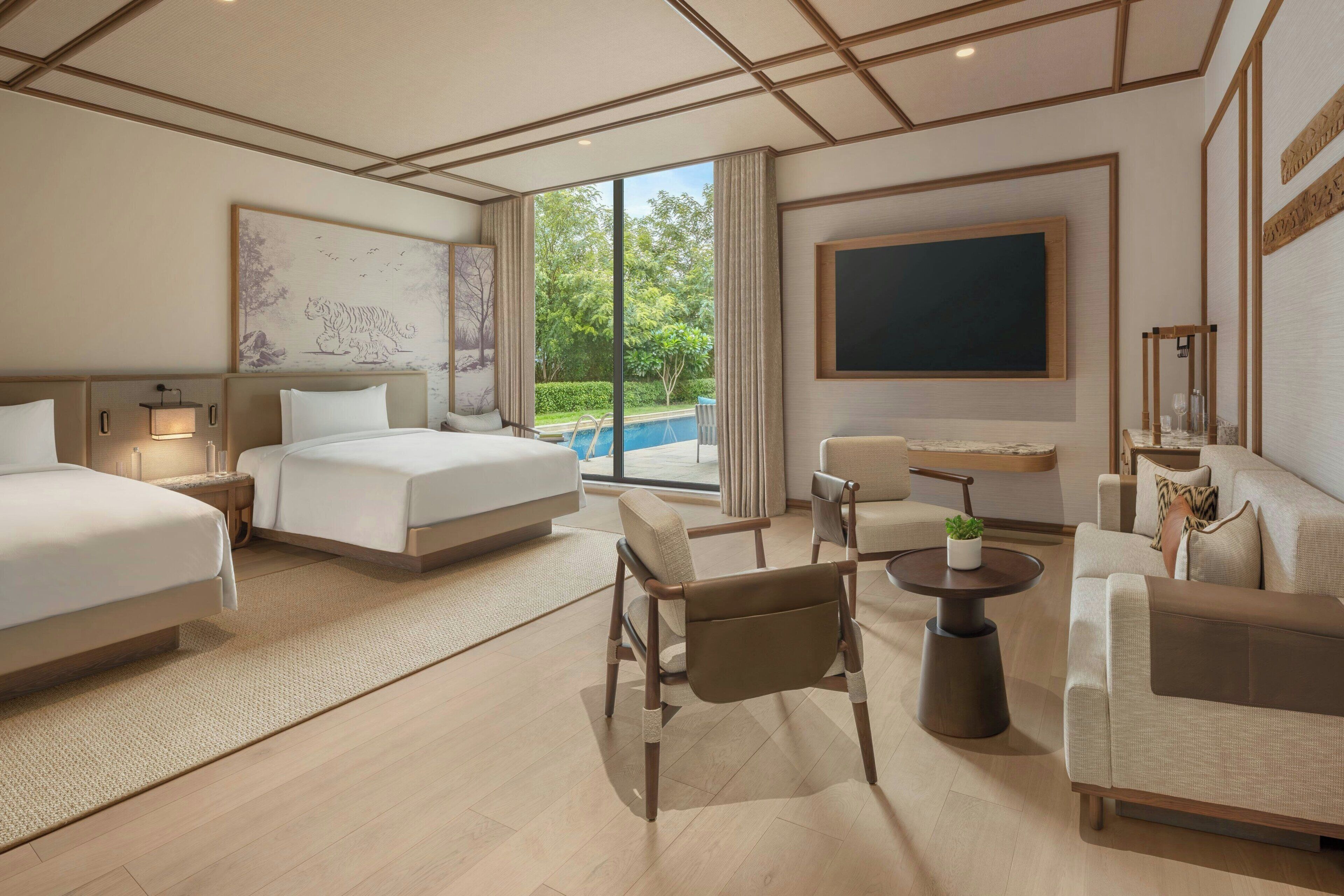 A hotel room with two beds, a sofa, a chair, a small table, and a large window offering a view of the outdoors.