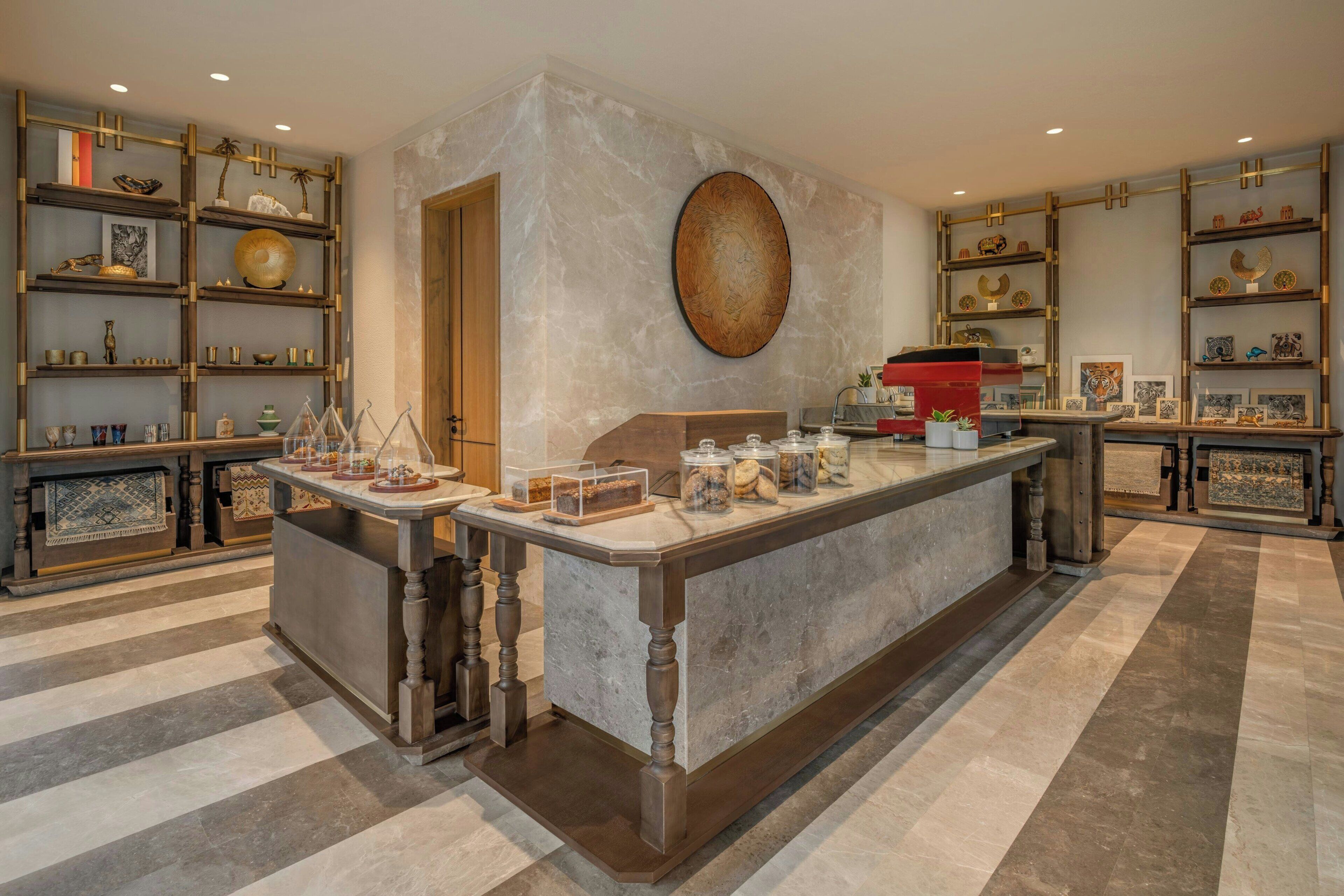 A spacious kitchen with a marble countertop, wooden cabinets, and a large island with glass jars.