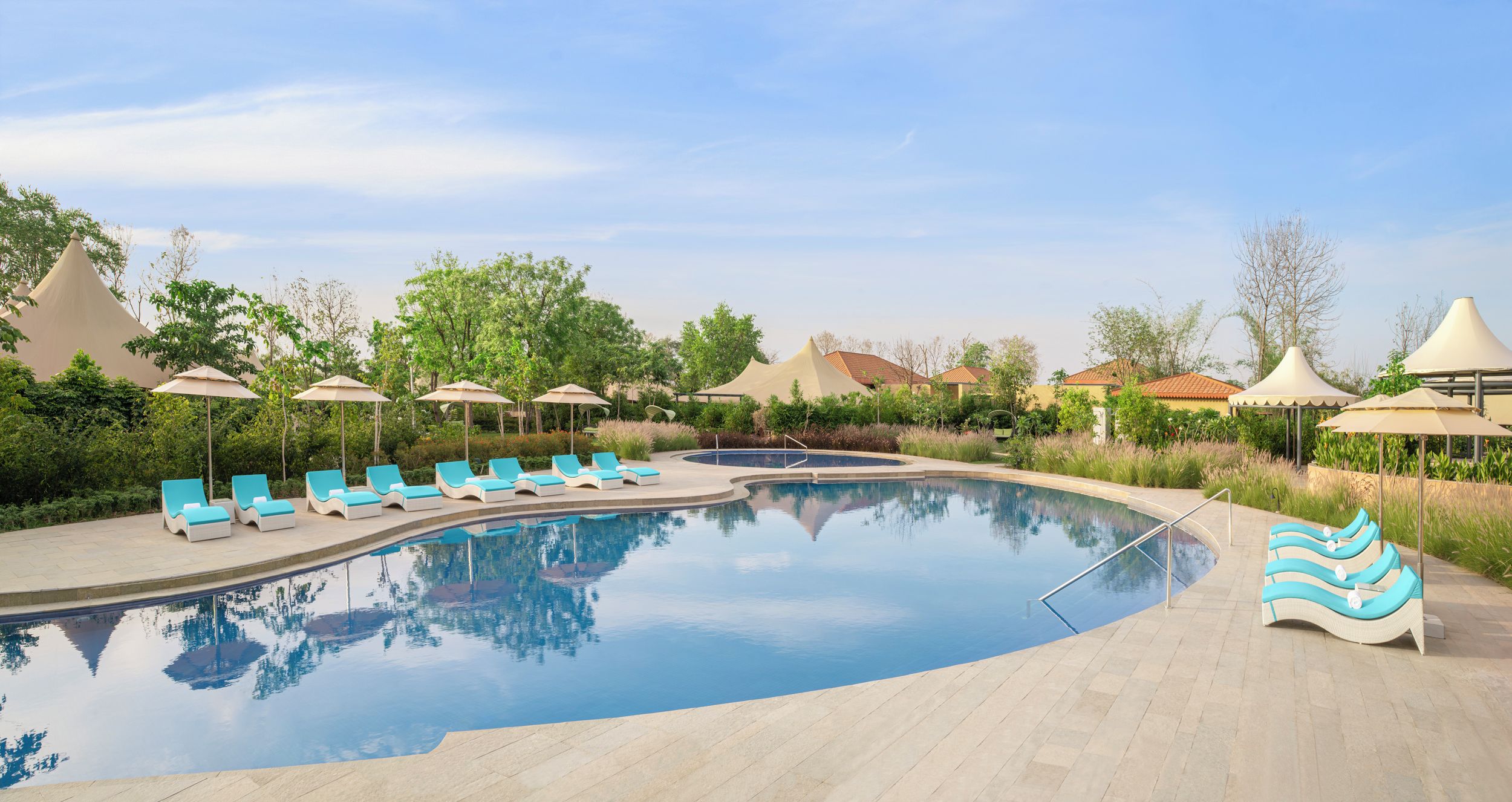 Ein Schwimmbecken mit Liegestühlen und Sonnenschirmen.