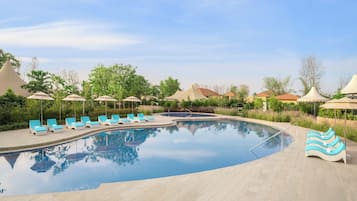 Ein Schwimmbecken mit Liegestühlen und Sonnenschirmen.