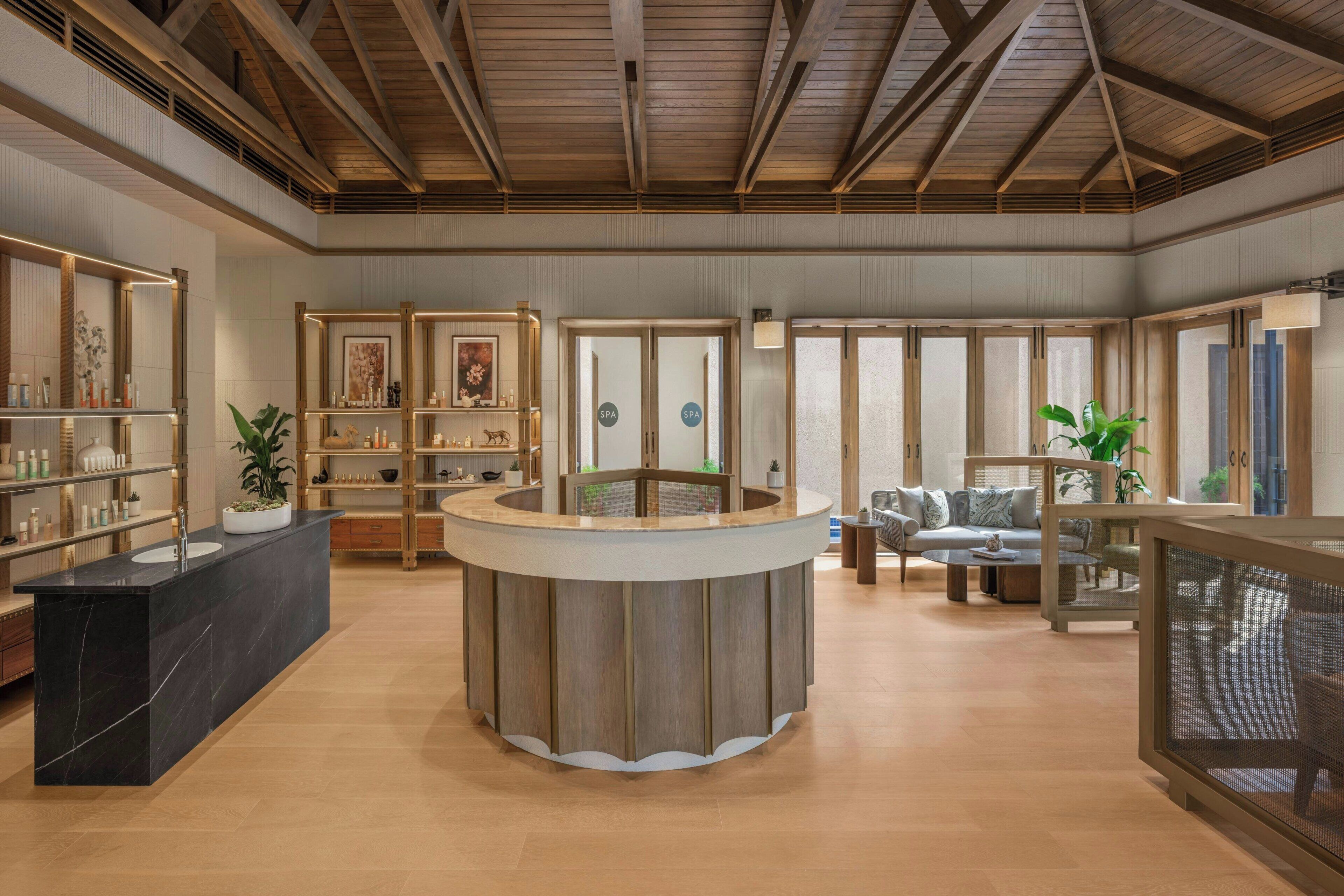 Un vestíbulo amplio con mostrador de recepción, zona de estar y señalización de spa.