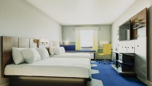 A hotel room with a bed, a desk, a chair, a television, and a minibar. - Microtel Inn & Suites by Wyndham Blytheville (Blytheville)
