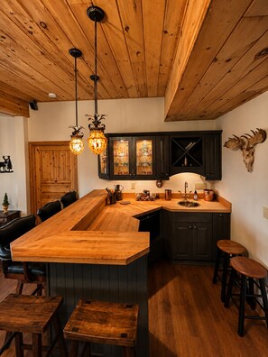 The downstairs features a cozy bar area with rustic wood finishes, seating, and a wet bar perfect for entertaining. A great space to gather for drinks, games, and relaxing after a day in the Blue Ridge Mountains. - Beautiful Mountain Getaway - Wolf Laurel Resort with Hot Tub, 4BDR, 3 Full Bathrooms, 2 Half Baths, and Mountain Views! (Mars Hill)