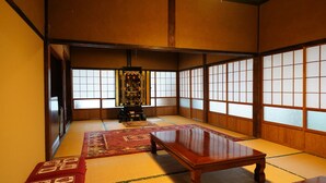 Ein traditioneller japanischer Raum mit Tatami-Böden, einem niedrigen Holztisch und verschiebbaren Shoji-Türen.