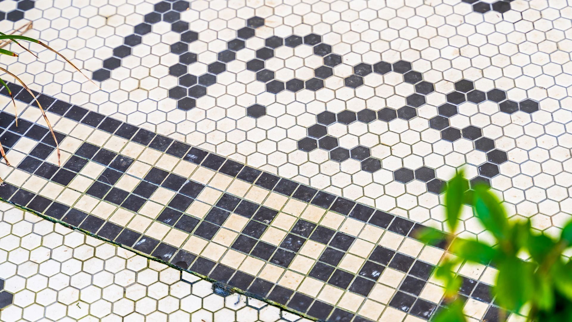 A close-up of a tiled floor with a pattern of hexagonal shapes in black and white.