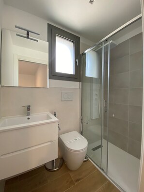A modern bathroom with a shower, toilet, and sink. - Modern accommodation with terrace (Bibione)