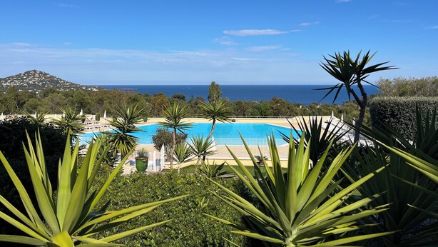 A pool with a view of the sea and a mountain in the background. - Studio with balcony, sea & golf view, swimming pool, parking-Hameau Cap Esterel (Saint-Raphaël)