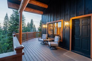 A wooden deck with outdoor seating, a door, and a view of trees. - The Summit House - Luxury Mountain Retreat (Shaver Lake)