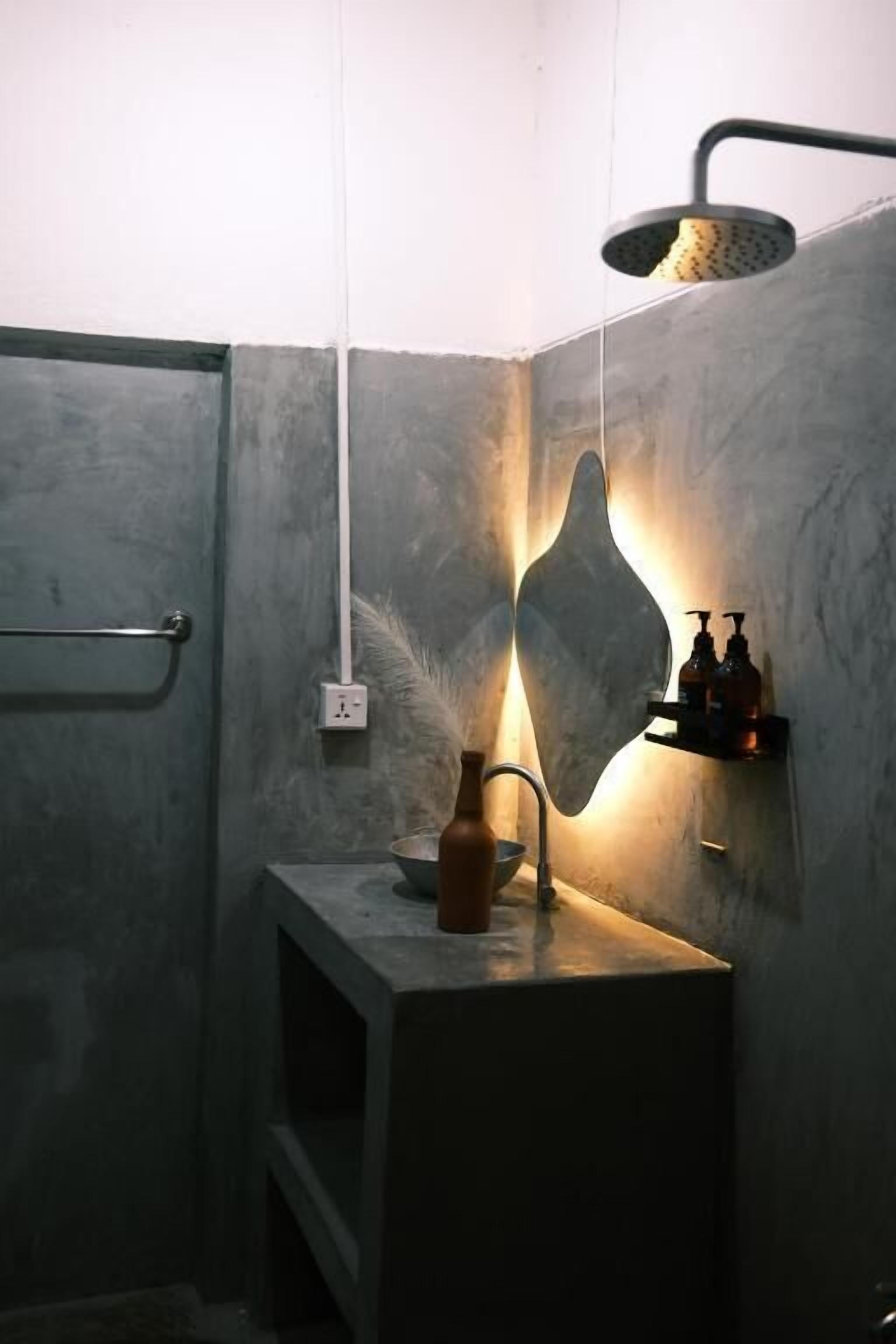 A bathroom with a shower, a sink with a bottle, and a towel rack.