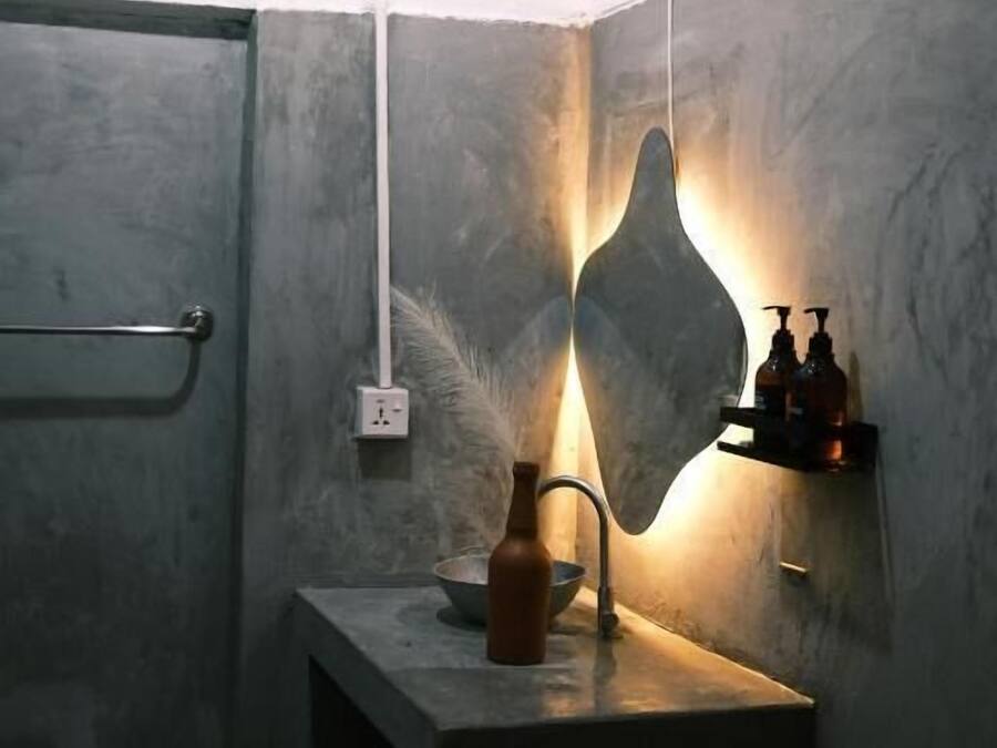 A bathroom with a shower, a sink with a bottle, and a towel rack.