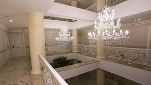 A grand interior with marble floors, ornate chandeliers, and a central open space with a fountain. - Hotel Antalya Beach Durres (Durrës)