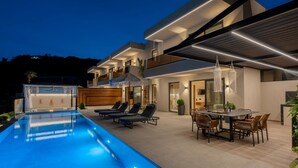 A modern house with a swimming pool, outdoor seating, and a dining area. - Azur Blue Luxury Villa (Mylopotamos)