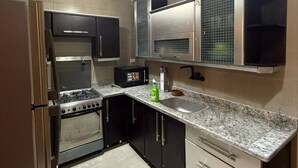 Une cuisine équipée d’une cuisinière, d’un four, d’un four à micro-ondes et d’un évier.