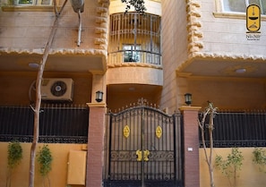 A multi-story building with a gated entrance, balconies, and a logo for 'Nb.Nir Pyramids Inn'. - Basuiony hotel  (Giza)