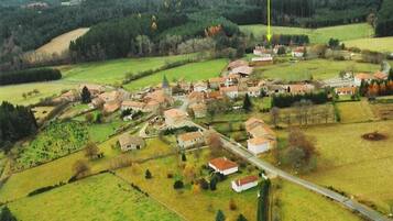 An aerial view of a village with houses, roads, and fields.