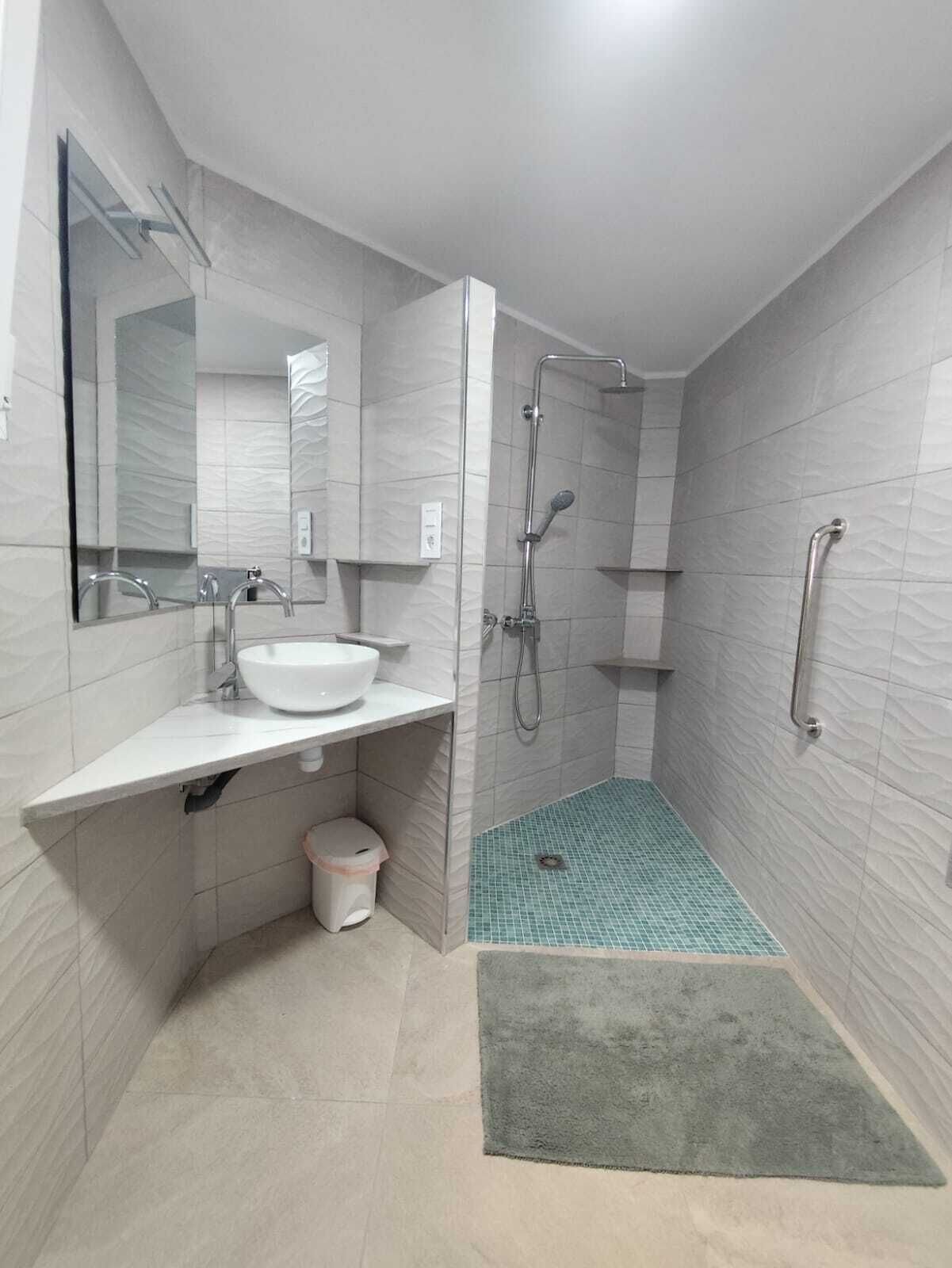 Een douche, handdoeken, zeep, toiletpapier