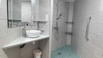 Een douche, handdoeken, zeep, toiletpapier
