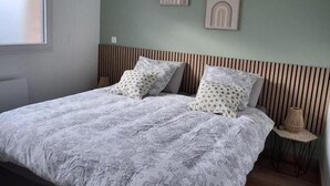 A bedroom with a bed, pillows, a wall with two framed pictures, a window, and a bedside lamp. - Charming lodging near Lille - 2 guests (SAINGHIN EN WEPPES)