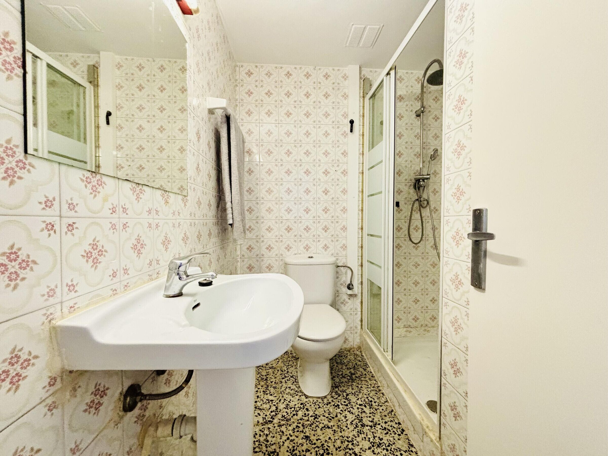 Un bany amb rentapisa, vàter i plat de dutxa.