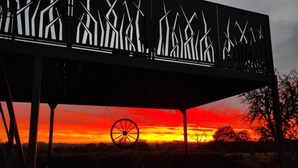 Une structure dotée d’un élément en forme de roue, d’une ossature métallique et offrant une vue sur le coucher de soleil.