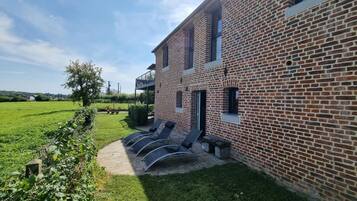 A brick building with a balcony and outdoor seating area.