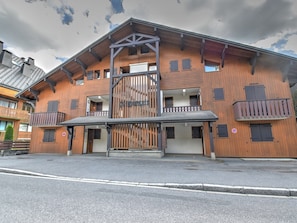A multi-story wooden building with balconies, a central entrance, and a staircase. - Charming apartment in Morzine - 4 guests (Morzine)