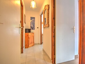 A hallway with a wooden cabinet, a mirror, and a door. - Charming apartment in Morzine - 4 guests (Morzine)