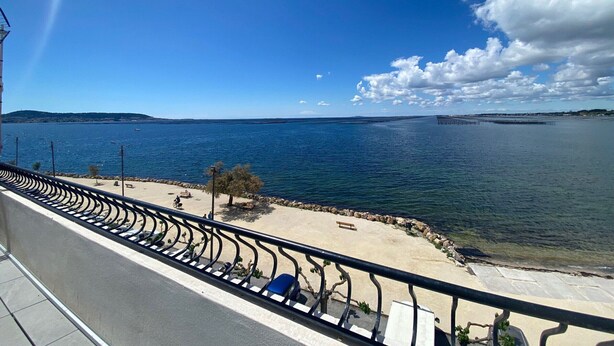 Vista costanera amb cel serè, platja sorrenca i mar tranquil·la.
