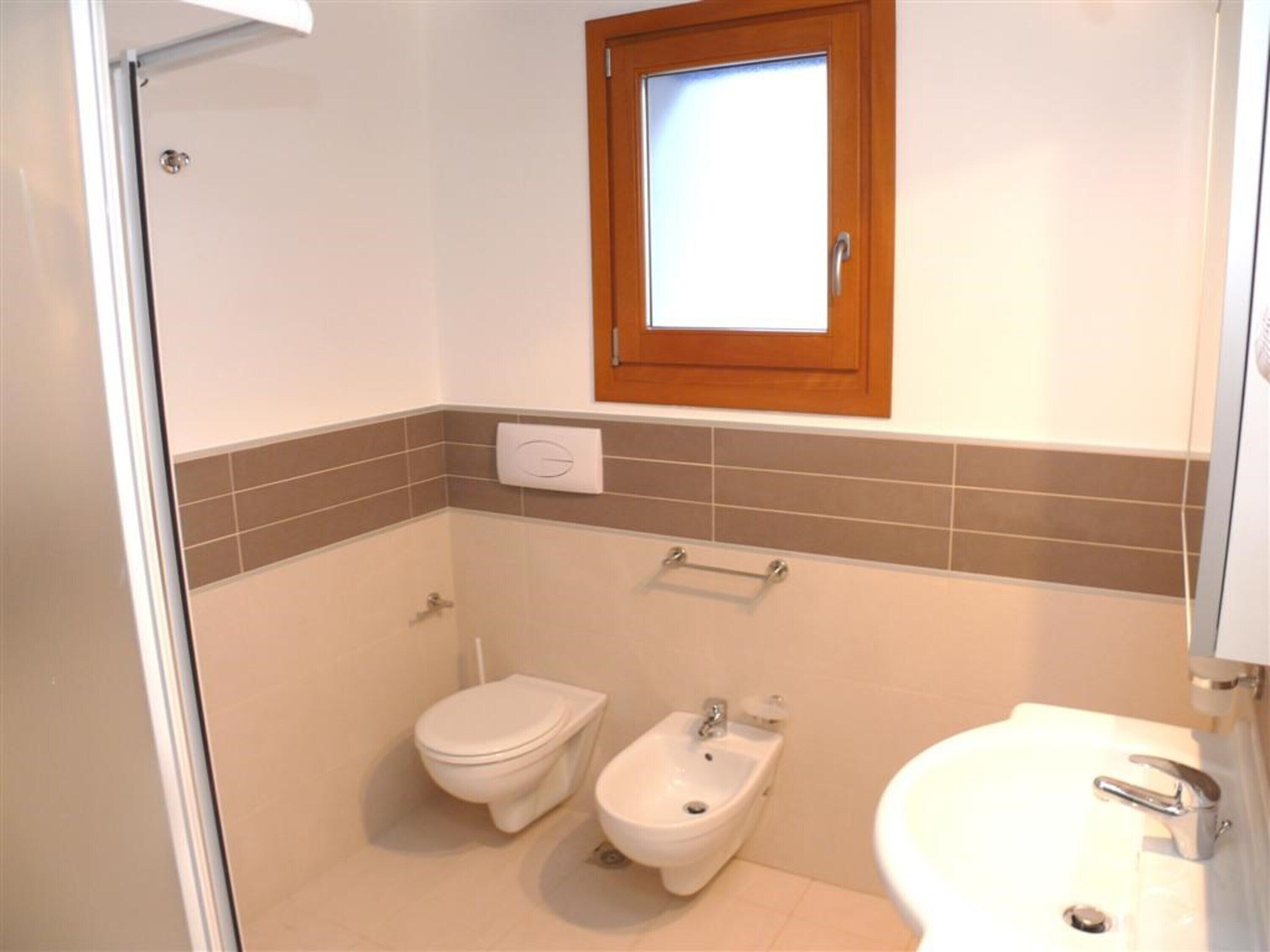 A bathroom with a toilet, bidet, and sink.